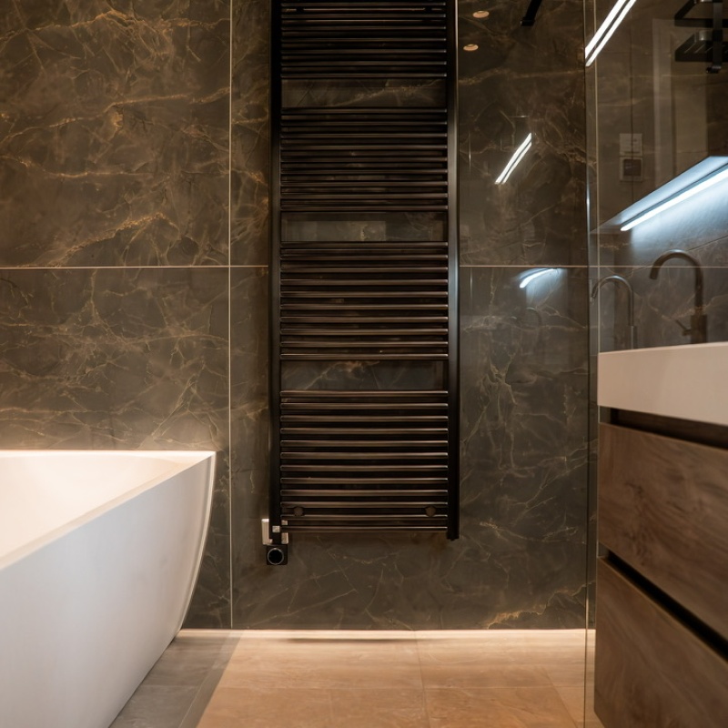 Overview of the bathroom with black designer towel radiator, freestanding bath, walk-in shower and dark marble-effect tiles in the A+++ renovated home in The Hague
