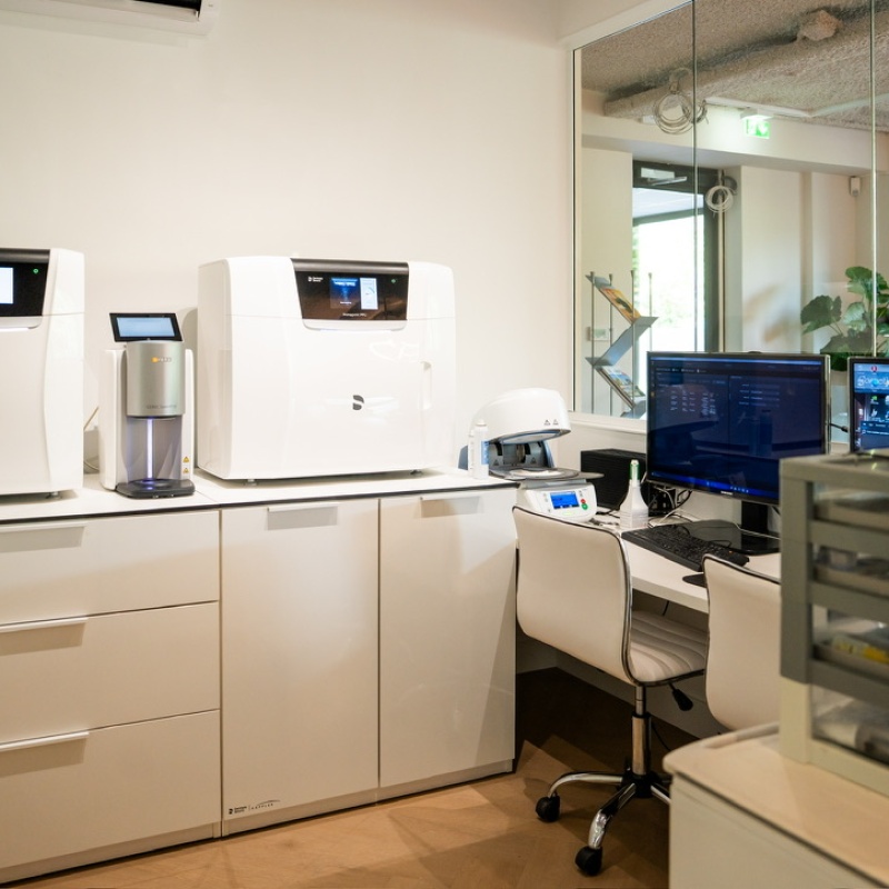 3D tooth design workspace with digital equipment and a monitor