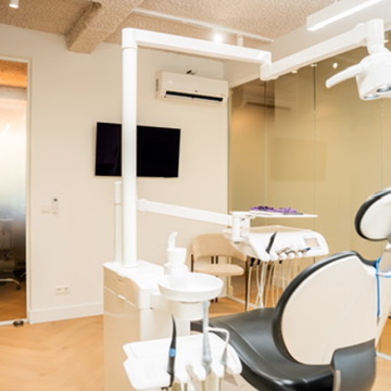 Treatment room with a dental chair and a wall-mounted monitor