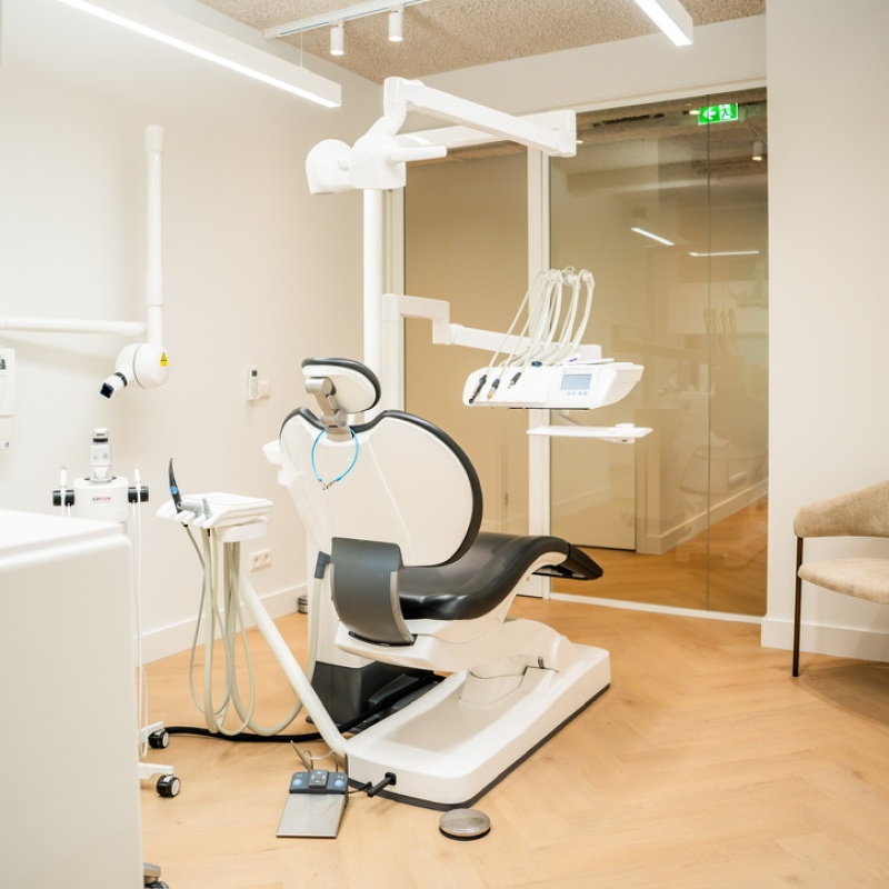 Overview of a treatment room with a dental chair, X-ray unit and waiting chair