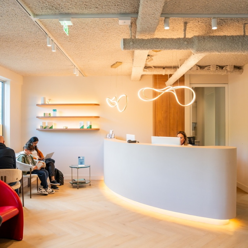 Reception and waiting area with a curved desk and ambient lighting