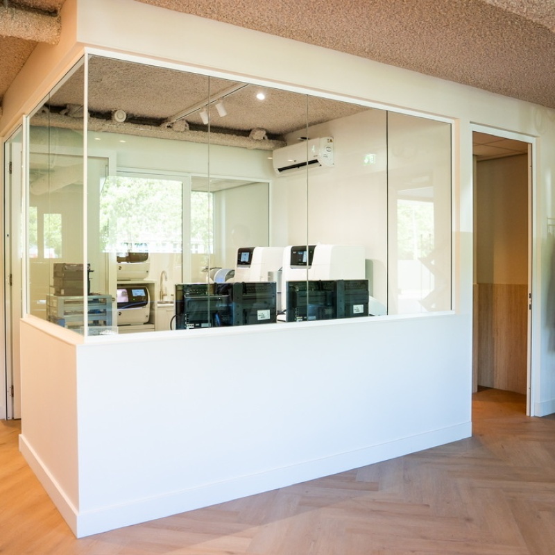Technical room behind glass with equipment and a coat rack